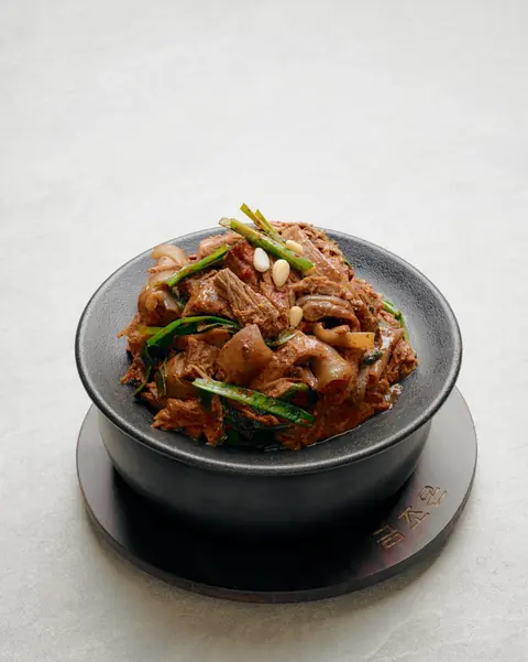 검은 뚝배기에 담긴 금조온 유량 흑염소 탕 흑염소볶음